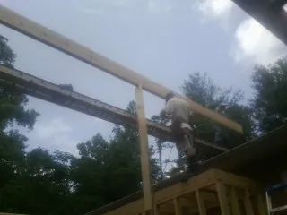 Carpenter setting a ridge beam over a new addition frame — Ice Dam Removal by Roofing Brothers in Elberfeld