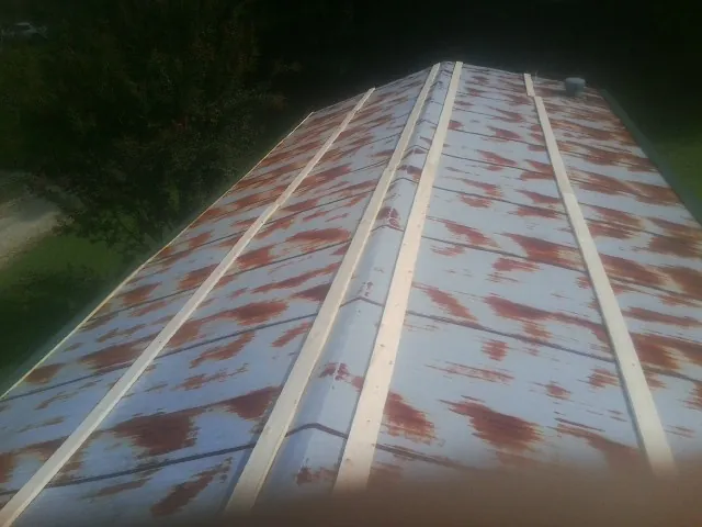Rusted metal roof panels with new wood purlins before replacement — Storm Damage Roof Repair in Elberfeld by Roofing Brothers