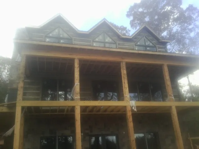 Dormers and porch framing on a large log home under construction — Roof Coating work by our crew in Elberfeld