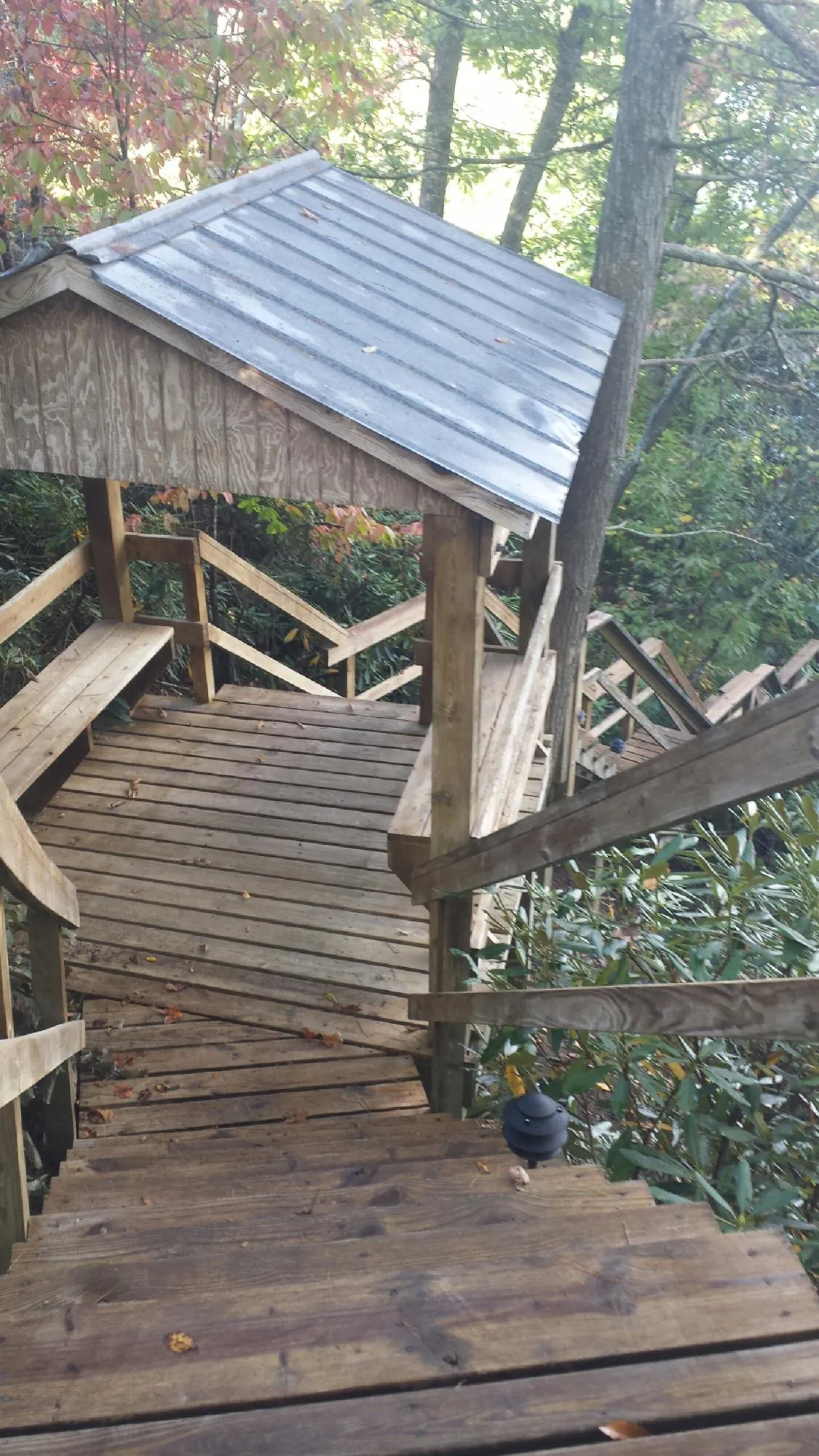 Metal roofed shelter over wooden steps on a wooded walkway — Skylight Repair & Installation work by our crew in Elberfeld