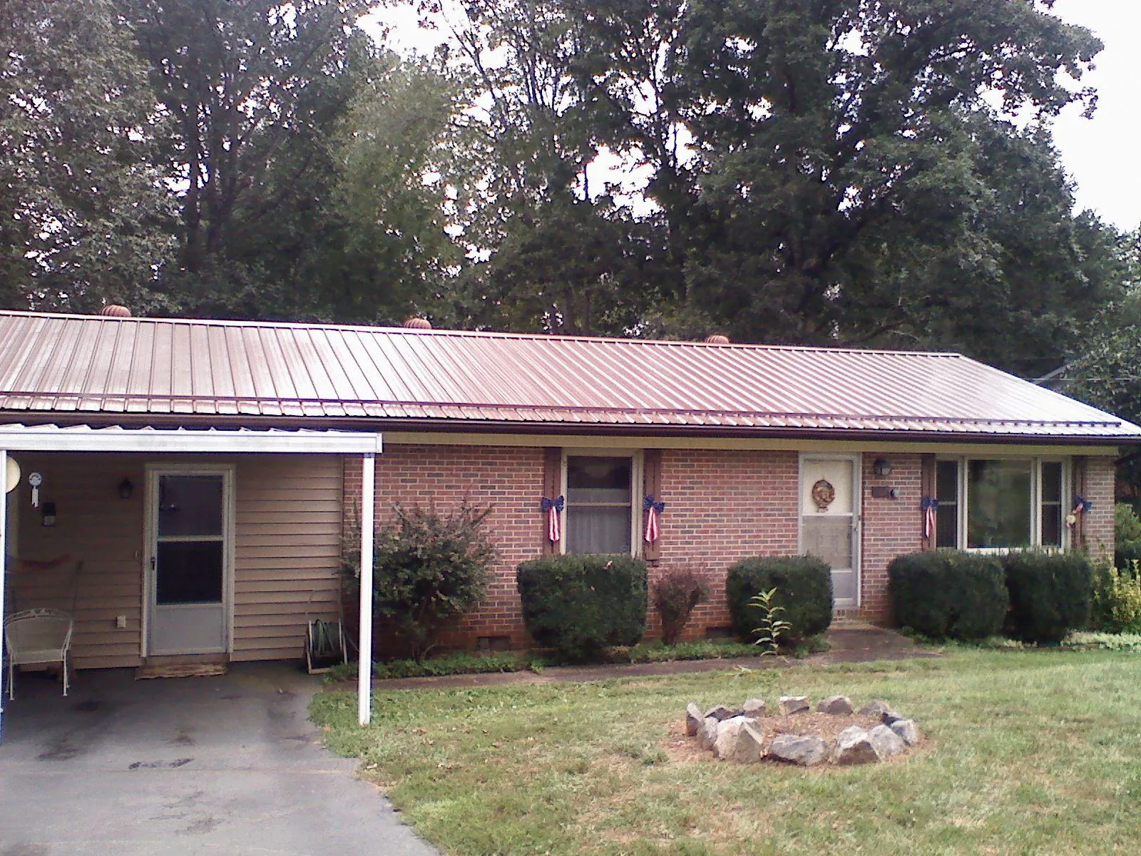 Bronze metal roof and carport on a brick ranch home — Roof Repair work by our crew in Elberfeld